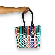 Indulge in luxury with our Bliss Totes, featuring the timeless Maria Victoria Bag in a captivating handwoven design. Made from repurposed plastic, this versatile bag is perfect for poolside lounging, beach outings, grocery excursions, and everyday tasks. With easy cleaning and fade-resistant colors, you'll never want to leave without it. Details: • Made in Mexico • Weight: 1 lb (453.59 g) • Dimensions: 8 x 4 x 8 in (20.3 x 10.2 x 20.3 cm) About this product: Color: Multicolor design Size: Mini Tote Perfect for everyday, indoor and outdoor activities.