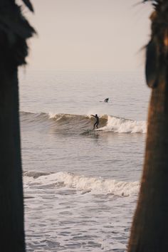 a man riding a wave on top of a surfboard