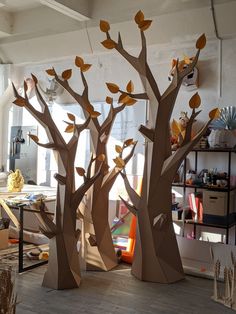 three cardboard trees with leaves on them in a room