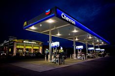 an empty gas station at night with the lights on