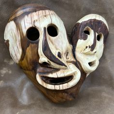 a wooden mask with two faces carved into it