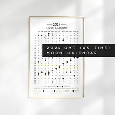 a calendar is hanging on the wall next to a black and white poster with yellow dots