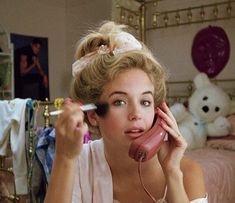 a woman is talking on the phone while holding a toothbrush