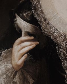 a close up of a person wearing a dress and holding a piece of cloth over their face