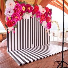 a black and white striped backdrop with flowers on it for an outdoor wedding ceremony at the beach