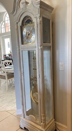 an antique grandfather clock in the corner of a room with tile flooring and walls