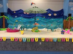 a stage set up for a children's birthday party with chairs and an umbrella