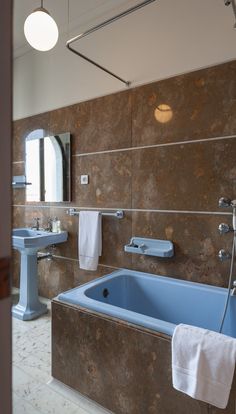 a bathroom with a blue bath tub next to a sink