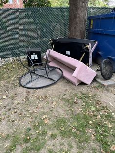 a blue dumpster sitting next to a pink blanket on top of a metal chair