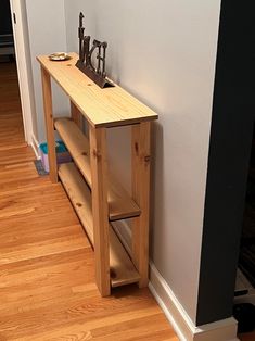 a wooden table sitting next to a wall with a clock on it's side