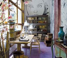 a living room filled with lots of furniture and flowers in vases on the table