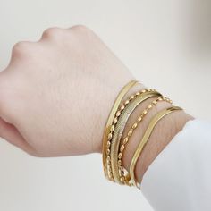 This five strands bracelet is perfect for those that loves minimalist pieces but wanted to create a classy stack that goes with any look. The detail of the different strands gives an unique touch and is the best of the two words: Minimalist but also elegant bold. Can be worn alone or with other bracelets. Bracelet Details: Material: 18K Gold Plated & Stainless Steel Length: 7' Inch Thickness: 8mm Quantity: 1 Color: Gold Does not tarnish/change color overtime Water Resistant Check Our Jewelry Car Gold Wrap Bracelet For Layering, Gold Multi-strand Stackable Bracelets, Elegant Stacked Gold Bracelets, Elegant Gold Stacked Bracelets, Elegant Adjustable Stacked Bracelets, Elegant Adjustable Stacked Beaded Bracelets, Minimalist Stackable Chain Bracelet For Layering, Modern Stackable Bracelets For Layering, Elegant Stacked Bracelets For Gift