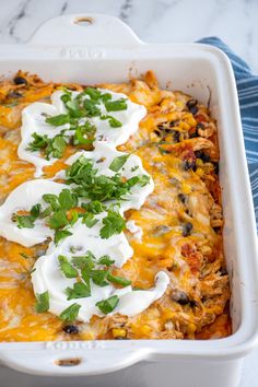 an enchilada dish with sour cream and cilantro