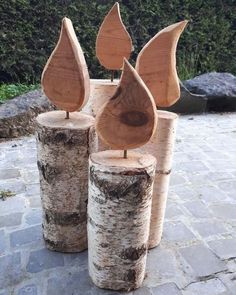 three pieces of wood sitting on top of each other in front of some rocks and trees