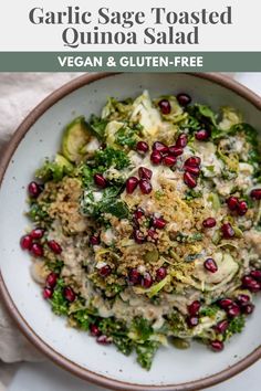 a white bowl filled with salad and topped with pomegranates on top