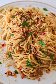 a white plate topped with spaghetti and parmesan