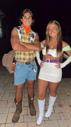 two people dressed in costumes standing next to each other on a brick walkway at night