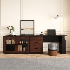 a room with a desk, chair and ottoman in it that has a rug on the floor