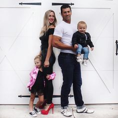 a man, woman and two children standing in front of a garage door