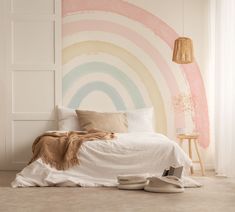 a bedroom with a rainbow painted on the wall next to a bed and two shoes