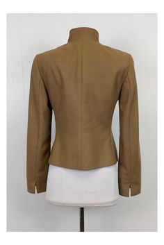 This tailored blazer is made in a rich tan color. Designed with a stand up collar and dark gold rounded buttons. It can be paired with fitted skirts or trousers. Size 6 60% wool, 40% angora Made in Switzerland Button down Dark gold buttons Stand Up collar Zip Up pockets Bust 36" Waist 32.5" Shoulder to hem 21.5" Fitted Brown Blazer For Work, Brown Fitted Blazer With Concealed Placket, Fitted Brown Blazer With Concealed Placket, Brown Fitted Blazer For Office, Classic Stand Collar Blazer For Office, Fitted Brown Blazer With Hidden Button Closure, Classic Office Blazer With Stand Collar, Fitted Beige Blazer With Concealed Placket, Fitted Stand Collar Outerwear For Business Casual