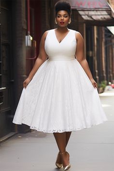 a woman in a white dress is walking down the street with her hands on her hips