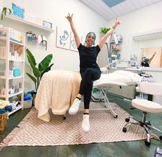 a woman sitting on top of a bed in a room with lots of furniture and decor