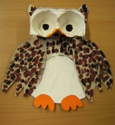 an owl made out of paper sitting on top of a wooden table