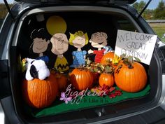 the trunk of a car with pumpkins and stuffed animals in it's trunk