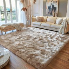 a living room filled with furniture and a large rug on top of a hard wood floor