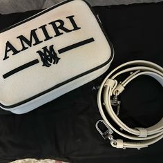 a white and black bag sitting on top of a bed