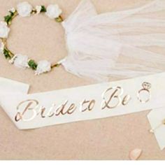 the bride to be sash is laying next to her wedding dress and flower headband