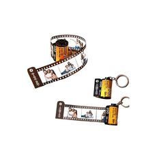 two film strip keychains with photos attached to them, one is holding a camera and the other has a bottle opener