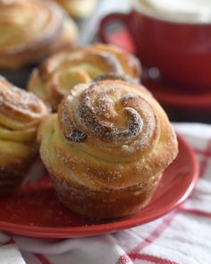 several pastries on a red plate with a cup of coffee in the background