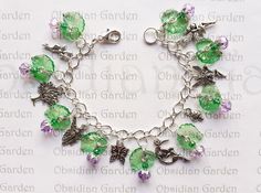 a green and purple bracelet with charms