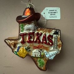 a texas shaped ornament with the word texas written on it