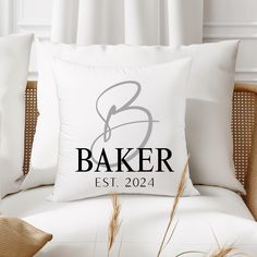 a white pillow sitting on top of a bed next to pillows and blankets with the word baker est 2024