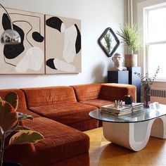 a living room filled with furniture and a large painting on the wall above it's coffee table