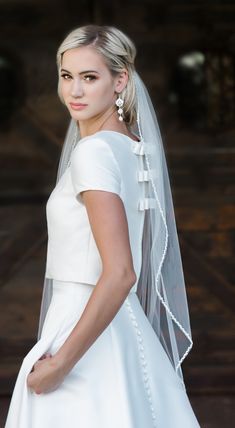 a woman in a white wedding dress and veil