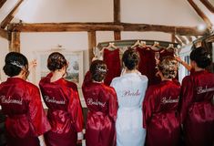 a group of women in red robes standing next to each other with their backs turned