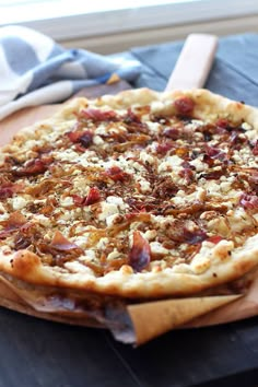 a pizza sitting on top of a wooden cutting board