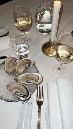 a table topped with oysters and wine glasses