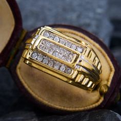 a gold and diamond ring sitting on top of a glove