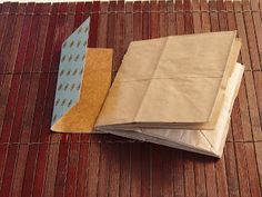 two brown bags sitting on top of a wooden floor next to each other with papers sticking out of them