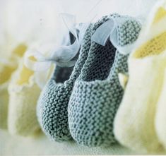 several knitted baby shoes lined up against a wall