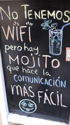 a chalk board with writing on it and a glass full of water next to the sign