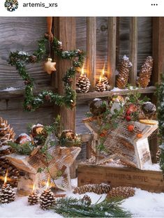 christmas decorations with pine cones and candles in the snow