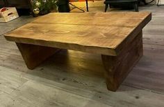 a wooden coffee table sitting on top of a hard wood floor next to a chair