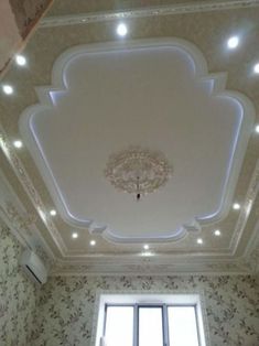 the ceiling in this room has been decorated with white and gold wallpaper, which is accented with chandelier lights