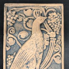 a decorative tile with a bird on it